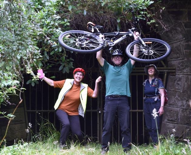 People_Excited_With_A_Bike_In_Front_Of_A_Gate_To_Tunnel